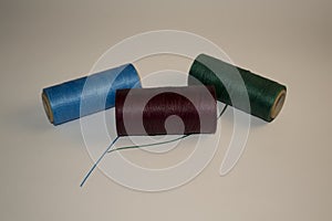 Rolls of red thread with needles
