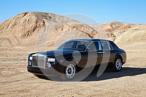 Rolls Royce car parked on unpaved road in front of mountains photo