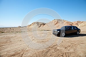 Rolls Royce car parked on unpaved road in front of mountains photo