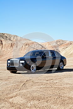 Rolls Royce parked on unpaved road with clear sky photo