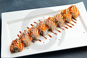Rolls with salmon in a plate. On a gray background