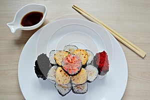 Rolls and sushi folded in the form of a cake on a white plate