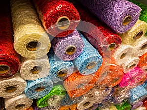 Rolls of textured decorative wrapping paper of different colors on the shelf in the store