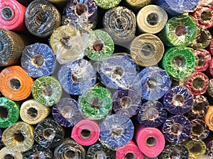 Rolls of textured decorative wrapping paper of different colors on the shelf in the store