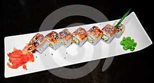 Rolls with tuna and shrimp, ginger, wasabi on a white long plate