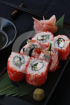 Rolls of uramaki sushi with rice nori seeweed and fish in a gourmet menu.