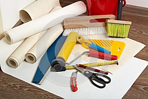 Rolls of wallpapers and various tools for wallpapering.