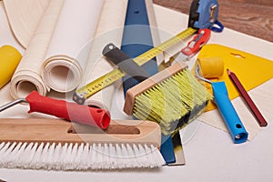 Rolls of wallpapers and various tools for wallpapering.