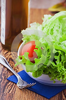 Romaine lettuce salad leaves and  tomatoes freshly washed on the dish close up ready for cooking