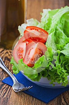 Romaine lettuce salad leaves and  tomatoes freshly washed on the dish close up ready for cooking