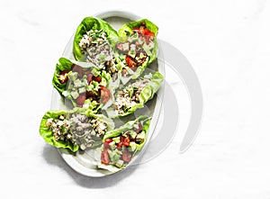 Romaine salad stuffed with tuna, egg, tomato, avocado salad on a light background, top view. Delicious appetizer, tapas, snack