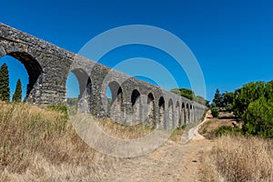 Roman aqueduct of Pegoes surrounded by greenery under sunlight in Tomar in Portugal photo