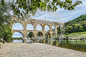 Roman aqueduct seen through foliage, Pont-du-Gard, Languedoc-Roussillon France