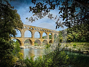 Roman aqueduct seen through foliage, Pont-du-Gard, Languedoc-Roussillon France