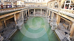 Roman Bath, UK - December 6, 2013: Tourists visiting inside Roman Baths complex. City of Bath is a UNESCO World Heritage Site. Se