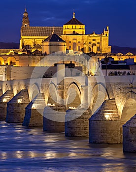 Roman Bridge on Guadalquivir river and The Great Mosque (Mezquita Cathedral) at twilight in the city of Cordoba, Andalusia