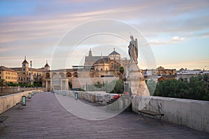 Roman Bridge at sunrise with San Rafael Statue and Cathedral of Cordoba - Cordoba, Andalusia, Spain
