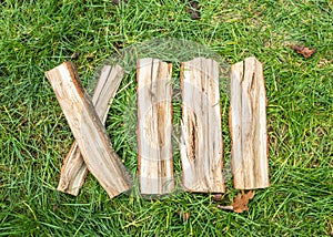 Roman numeral. Roman numerals made from oak. Old wood numbers. Old roman antique alphabet number on green grass background. Number