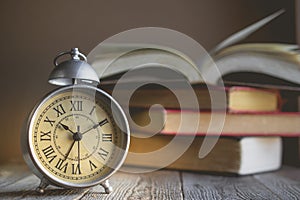 Roman Numeral in Vintage Alarm Clock and Open Book Background wi