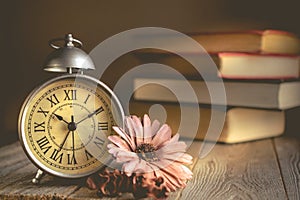 Roman Numeral in Vintage Alarm Clock and Stack of Book Background