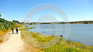 Pilgrims walking in way of Santiago Via de la Plata near the Roman dam of Proserpina, province of Badajoz, Spain photo