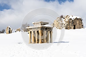 Roman ruins in Faqra, Tower of Claudius and the small altar covered in snow on a cloudy day, Lebanon photo