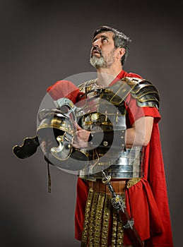 Roman soldier looking up while holding his helmet