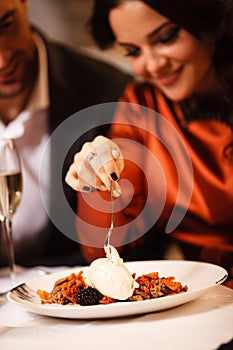 Romance and dating concept. Young couple man and woman celebrating and eating delicious dessert in restaurant. Two