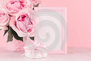 Romance festive interior - delicate pastel pink flowers, blank frame and gift box with gentle ribbon and bow on white wooden table