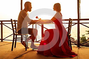 Romance marriage proposal by the sea tropical paradise beach beachfront restaurant.a man in a white shirt and a