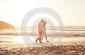 Romance never gets old. Full length shot of an affectionate middle aged couple walking hand in hand along the beach at