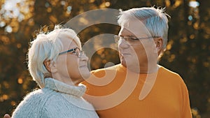 Romance at old age. Retired couple enjoying autumn picnick. Looking at each other