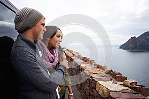 Romance on top of the world. a young couple enjoying the view while out on a drive in the country.