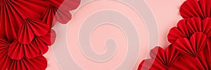 Romance Valentines day banner with passion red paper hearts as sideways border, frame on pastel pink background, top view, closeup