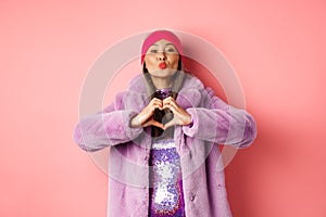 Romance and valentines day. Happy asian senior woman showing heart sign, I love you gesture, pucker lips for kiss