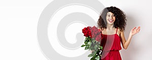 Romance and Valentines day. Woman gasping surprised and happy, receive surprise gift from lover, holding bouquet of red