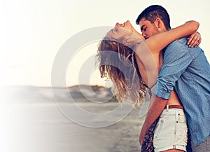 Romancing the summer days away. an affectionate young couple at the beach.