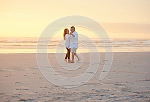 Romancing their retirement away. a mature couple dancing on the beach.