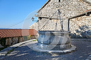 Romanesque House and Rainwater Drains and a Stone Fountain in Stanjel Slovenia photo