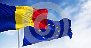 Romania and European Union flags waving in the wind on a clear day
