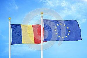 Romania and European Union two flags on flagpoles and blue sky