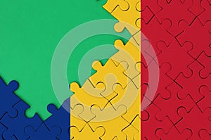 Romania flag is depicted on a completed jigsaw puzzle with free green copy space on the left side