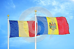 Romania and Moldova two flags on flagpoles and blue sky