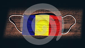 Romania National Flag at medical, surgical, protection mask on black wooden background. Coronavirus Covidâ€“19, Prevent infection