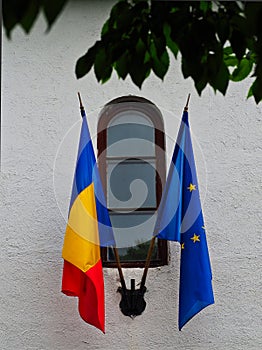 Romanian and European Union Flags on White Building
