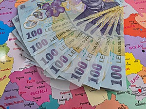 Romanian 100 Lei banknotes on a map of Romania
