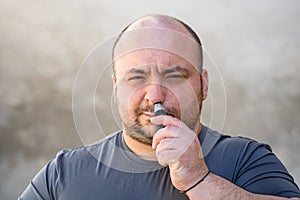 A Romanian male shaving or trimming his nose hair using a hair clipper or electric razor