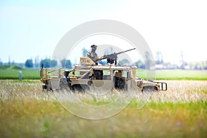 Romanian soldiers man a Humvee armored vehicle on a field, on a sunny summer day during a drill