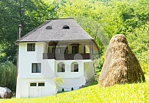 Romanian traditional villa with haystack and green grass - Oltenia province, Romania