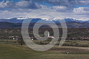 Romanian village with the Carpathian mountains in the background covered in snow